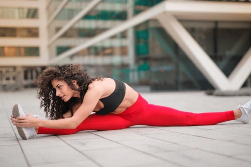 Femme qui fait des étirements avec une tenue de sport