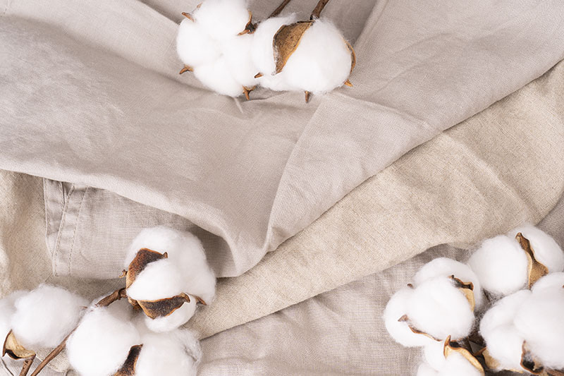 Fleurs de coton sur un tas de linge en coton naturel biologique